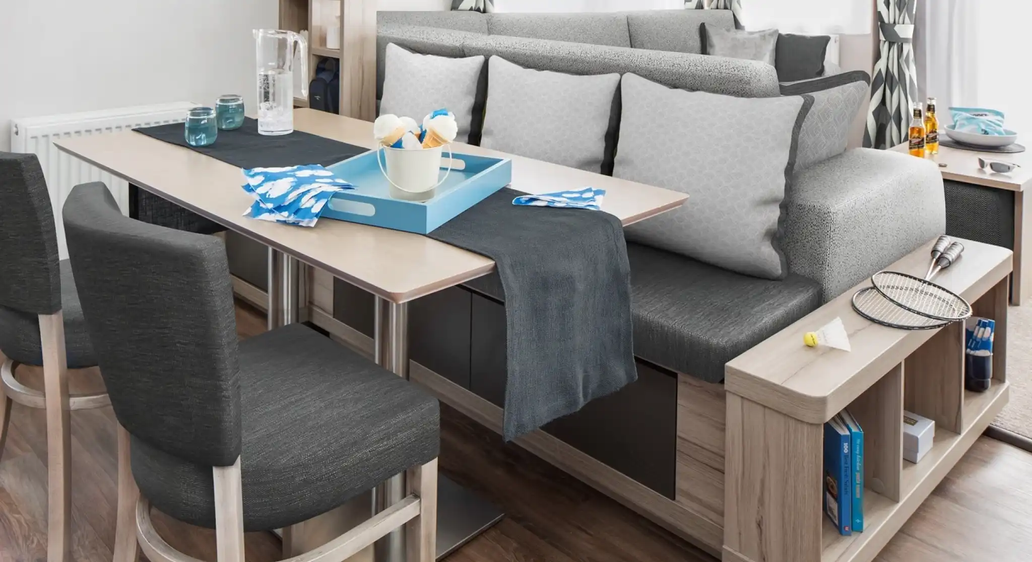 Modern dining area with a dining table, bench seating and integrated shelving.
