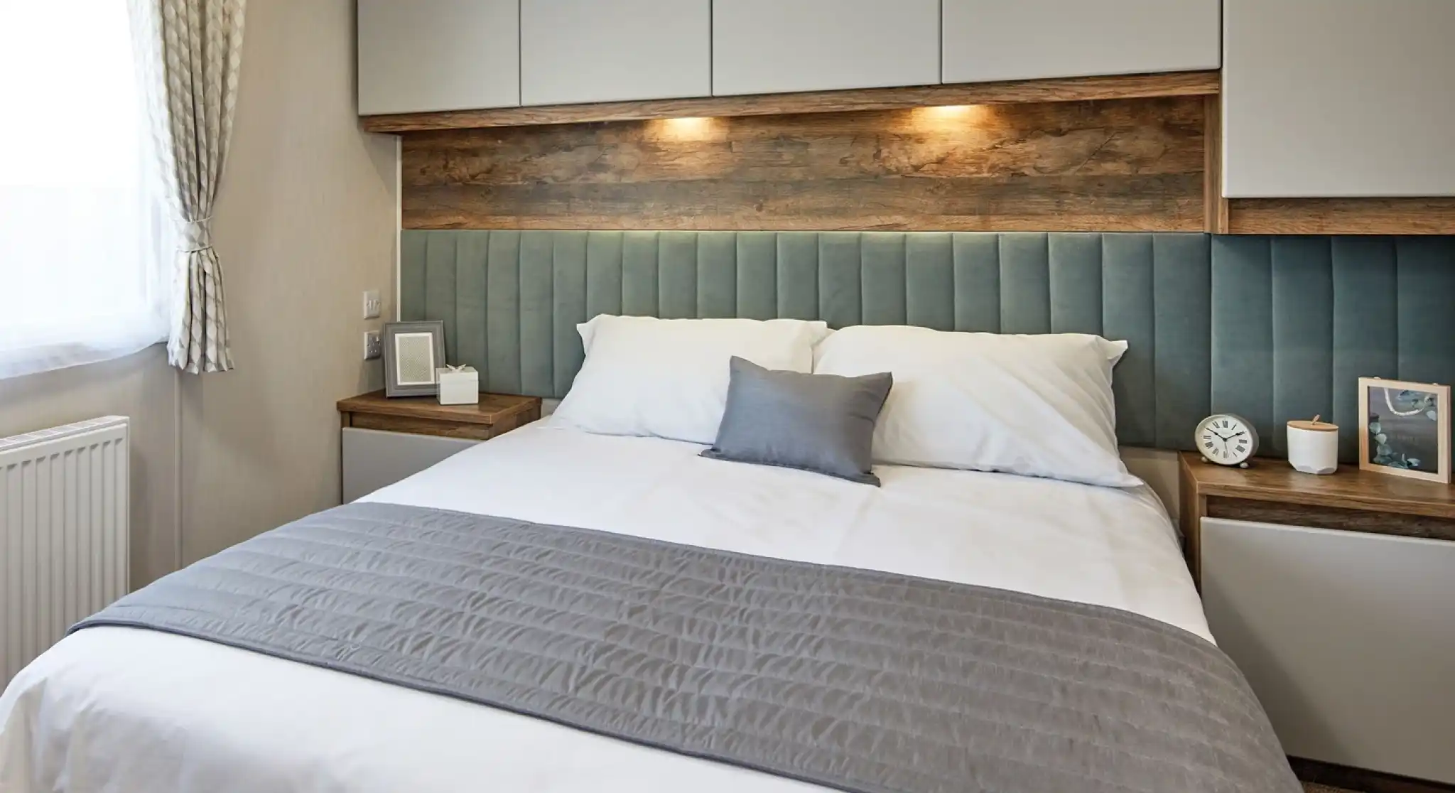 A double bedroom featuring a bed with a stylish headboard, accompanied by two nightstands. The bed is dressed with soft linens, pillows, and a duvet cover. The room has an inviting atmosphere with modern interior design elements adding to the overall aesthetic.