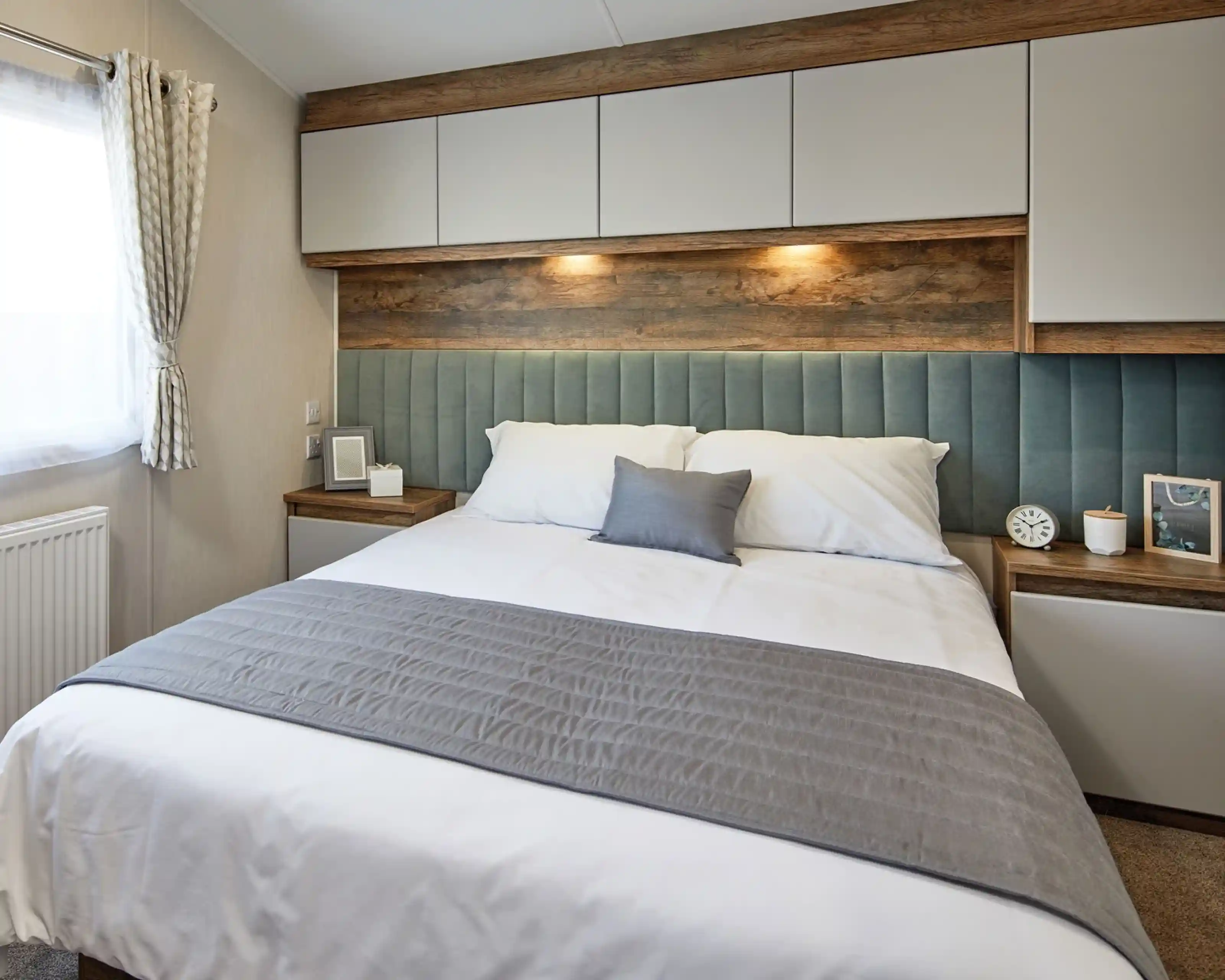 A double bedroom featuring a bed with a stylish headboard, accompanied by two nightstands. The bed is dressed with soft linens, pillows, and a duvet cover. The room has an inviting atmosphere with modern interior design elements adding to the overall aesthetic.