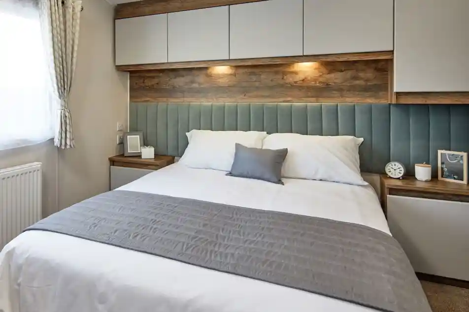 A double bedroom featuring a bed with a stylish headboard, accompanied by two nightstands. The bed is dressed with soft linens, pillows, and a duvet cover. The room has an inviting atmosphere with modern interior design elements adding to the overall aesthetic.