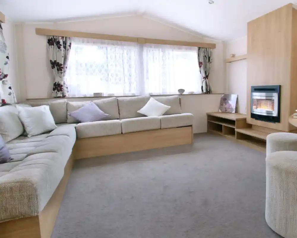 A spacious sitting and dining room with l-shaped sofa and feature fireplace.