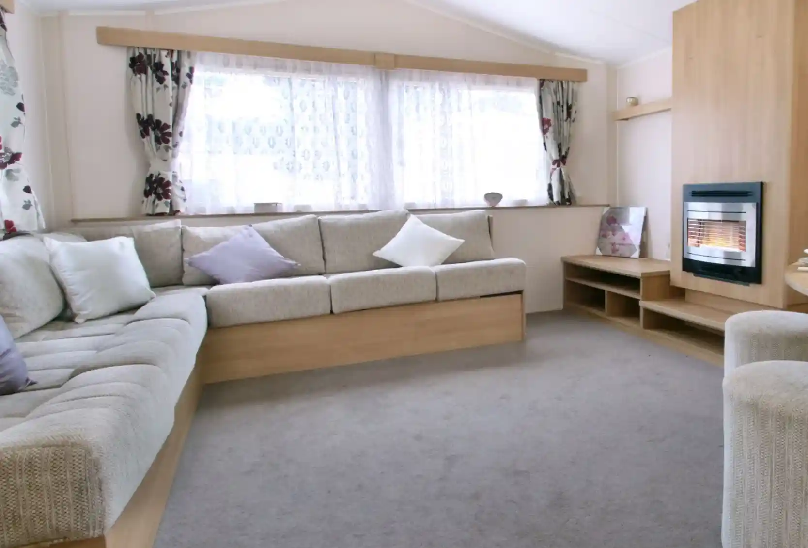A spacious sitting and dining room with l-shaped sofa and feature fireplace.