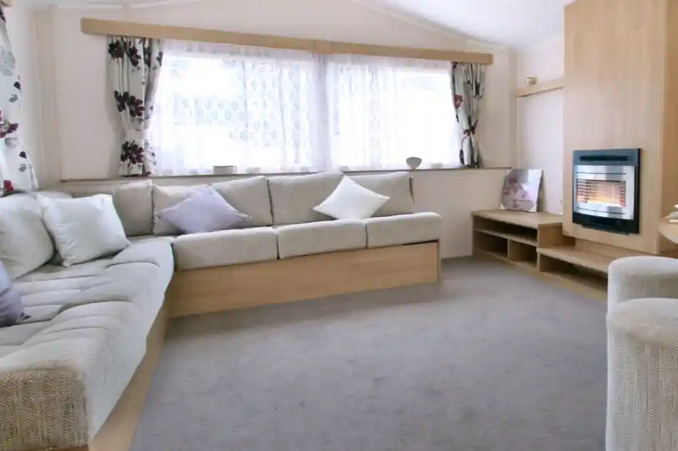 A spacious sitting and dining room with l-shaped sofa and feature fireplace.