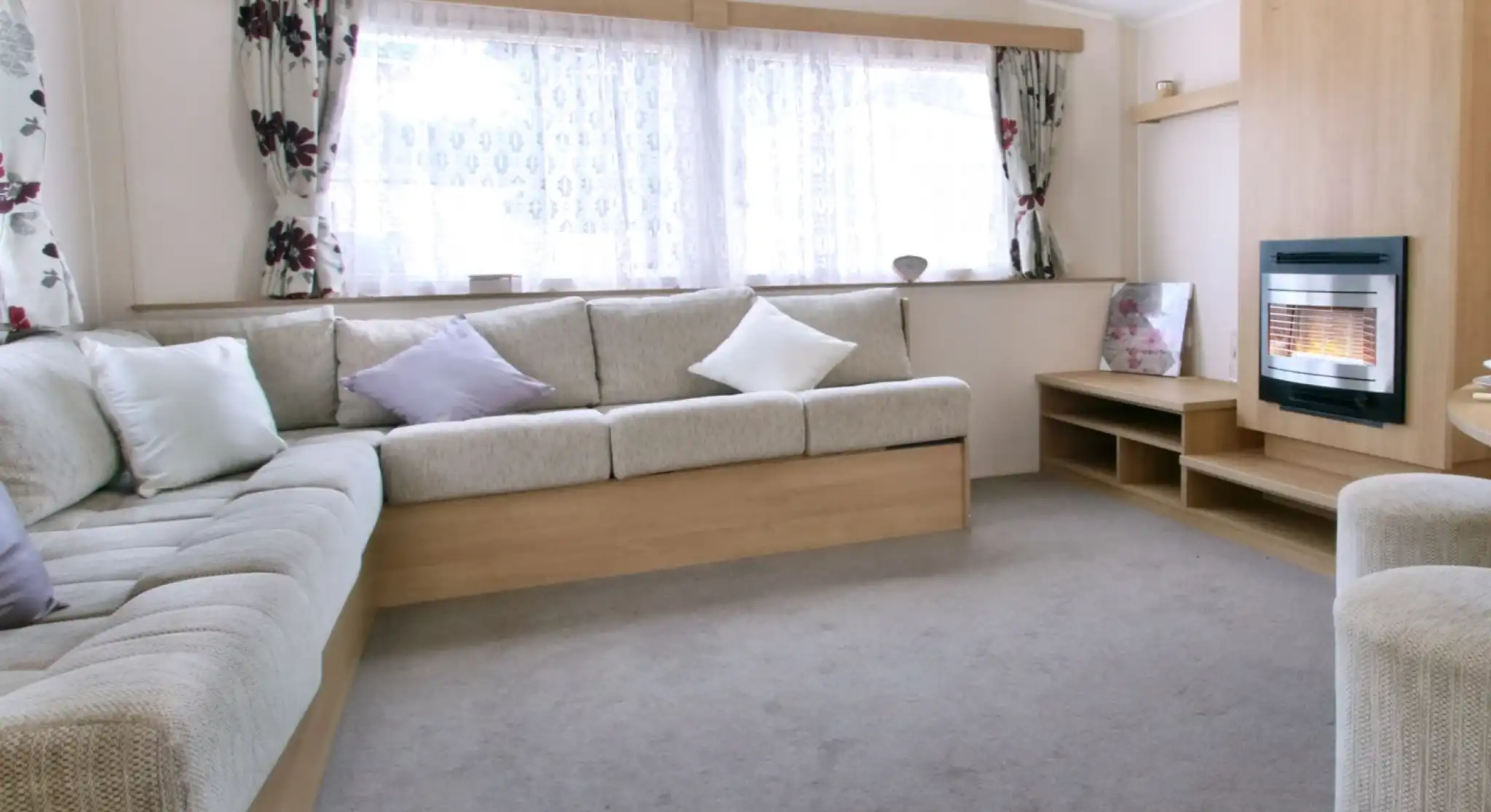 A spacious sitting and dining room with l-shaped sofa and feature fireplace.