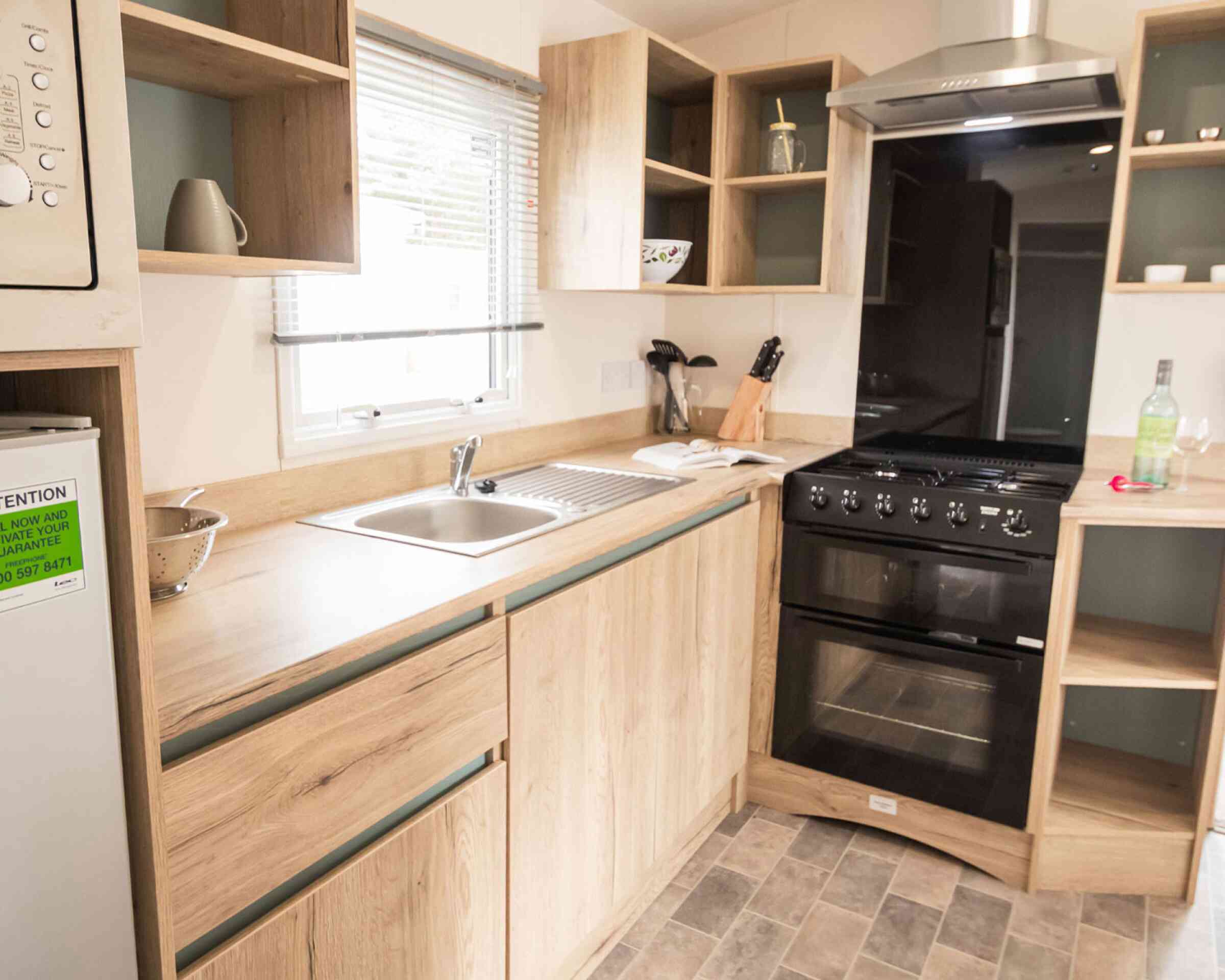 A well-equipped modern kitchen displaying a stove, oven, sink and refrigerator, highlighting essential cooking appliances.
