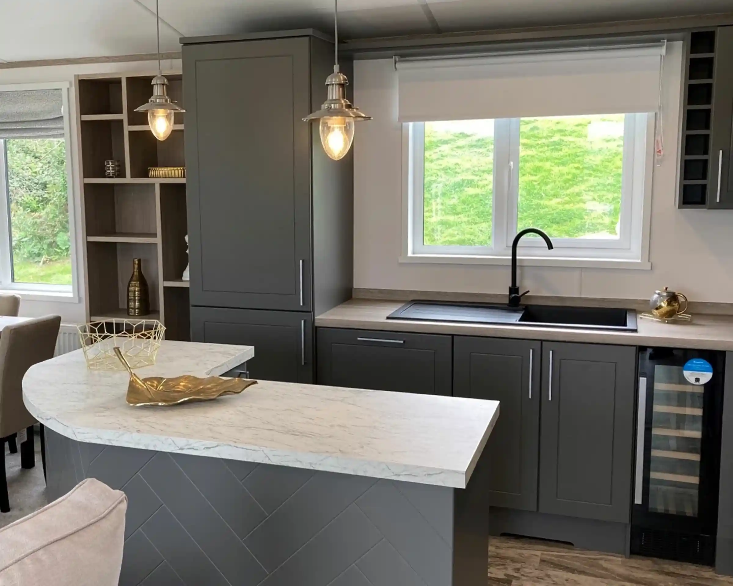 Stylish kitchen in the Atlas Lilac Lodge with grey cabinetry, marble-style countertops and peninsular breakfast bar.