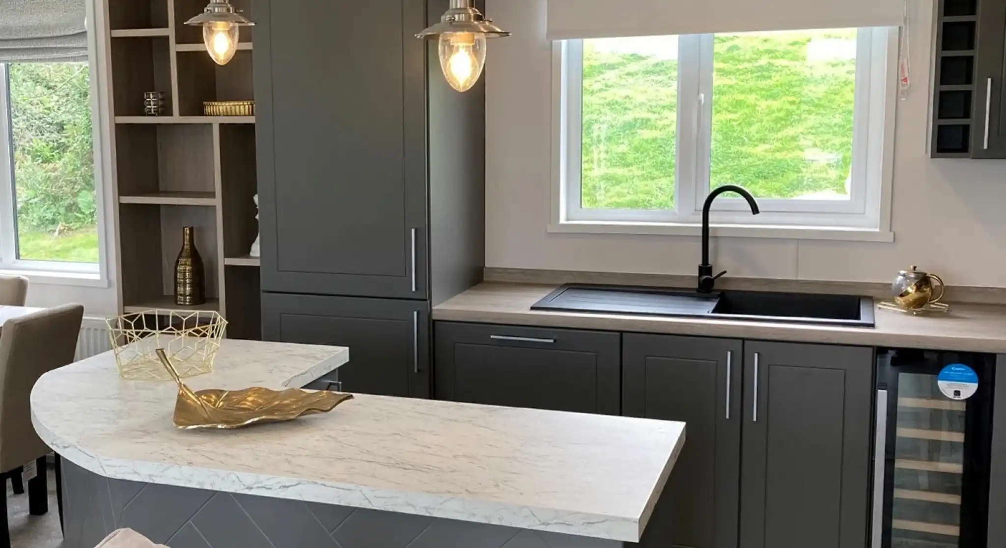 Stylish kitchen in the Atlas Lilac Lodge with grey cabinetry, marble-style countertops and peninsular breakfast bar.