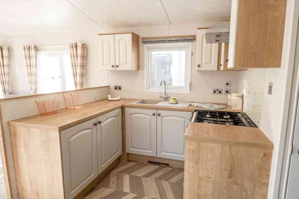 A well-equipped kitchen with a sink, stove, oven and microwave, designed for meal preparation.