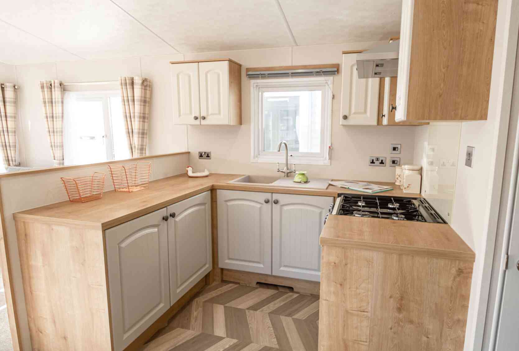 A well-equipped kitchen with a sink, stove, oven and microwave, designed for meal preparation.
