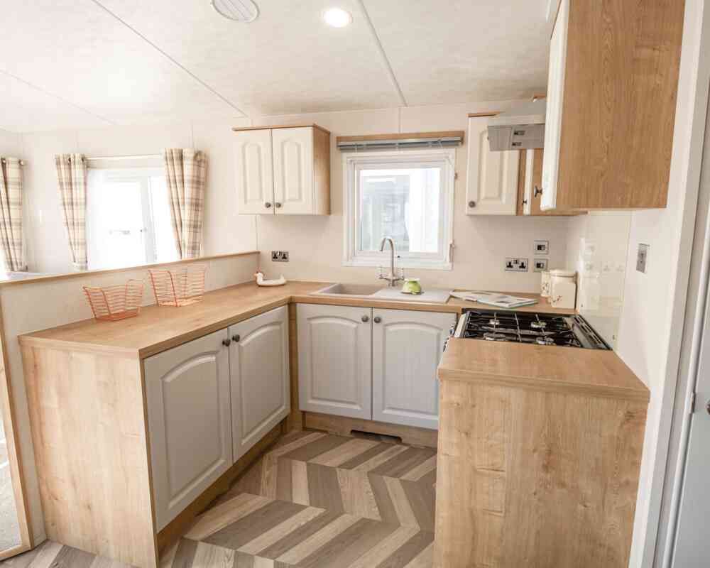A well-equipped kitchen with a sink, stove, oven and microwave, designed for meal preparation.