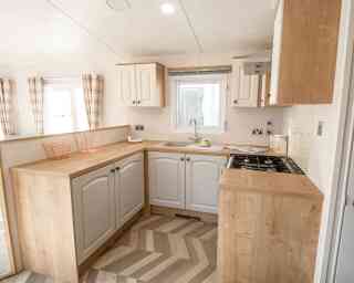A well-equipped kitchen with a sink, stove, oven and microwave, designed for meal preparation.