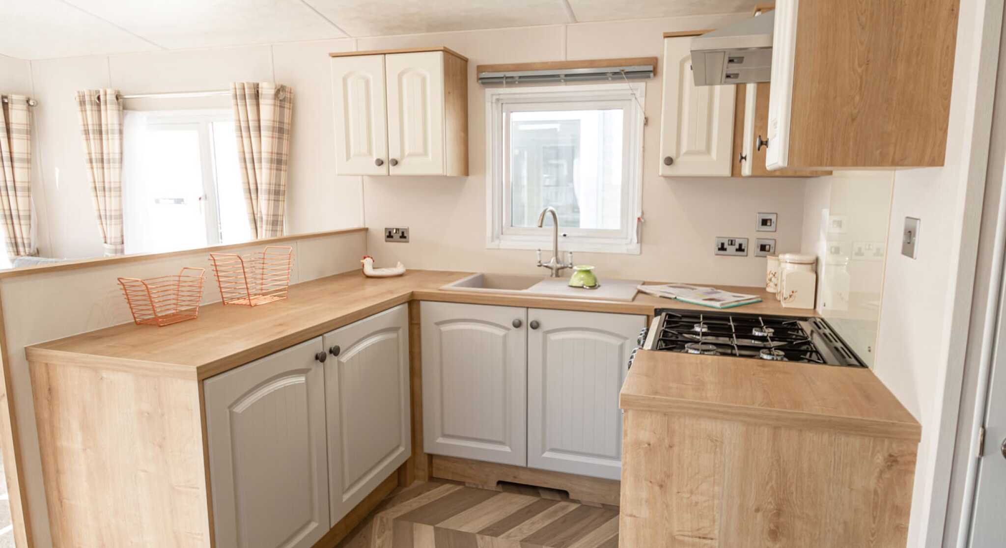 A well-equipped kitchen with a sink, stove, oven and microwave, designed for meal preparation.