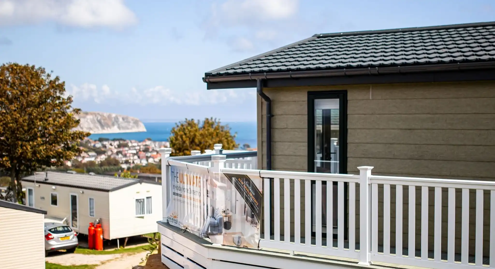 Lodge with decking overlooking Swanage bay on a sunny day