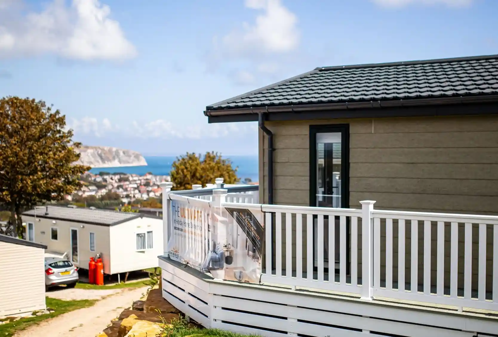 Lodge with decking overlooking Swanage bay on a sunny day