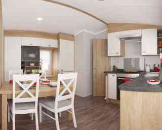 Stylish kitchen with wooden accents, light cupboards, and a dining table with white chairs set for a meal, exuding warmth and comfort.