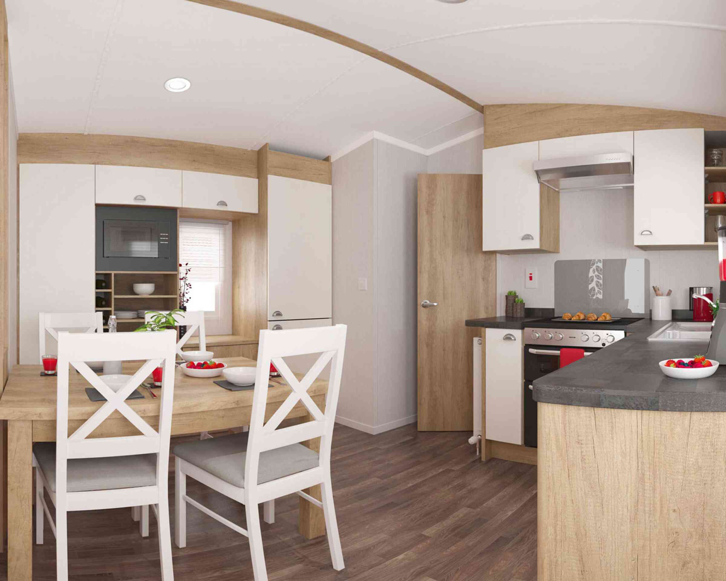 Stylish kitchen with wooden accents, light cupboards, and a dining table with white chairs set for a meal, exuding warmth and comfort.