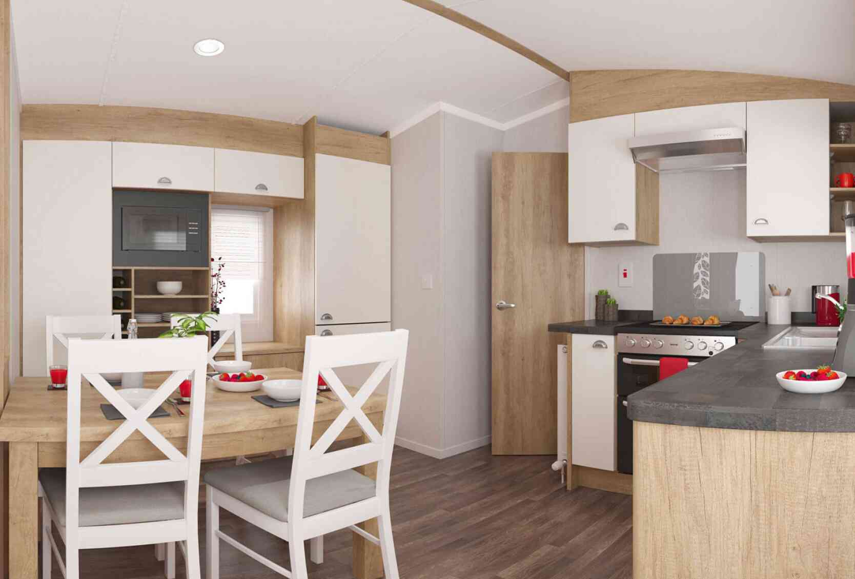 Stylish kitchen with wooden accents, light cupboards, and a dining table with white chairs set for a meal, exuding warmth and comfort.